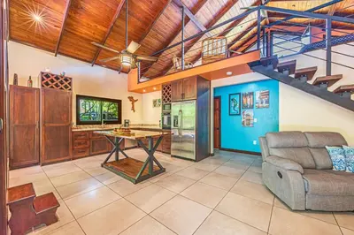 a living room with a ping pong table and a staircase at Casa de los Lorros close to whale tail in Bahia