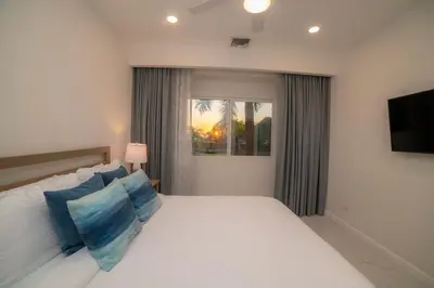 a bedroom with a large white bed with blue pillows at Del Mar 1G 3 bdr - 2bth ocean view in Herradura
