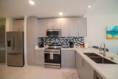 a kitchen with white cabinets and a stainless steel refrigerator at Del Mar 1G 3 bdr - 2bth ocean view in Herradura