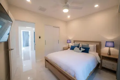 a bedroom with a large bed with blue pillows at Del Mar 1G 3 bdr - 2bth ocean view in Herradura