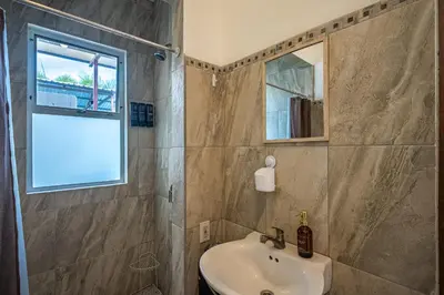 a bathroom with a sink and a mirror at Casa Alegria in Jacó
