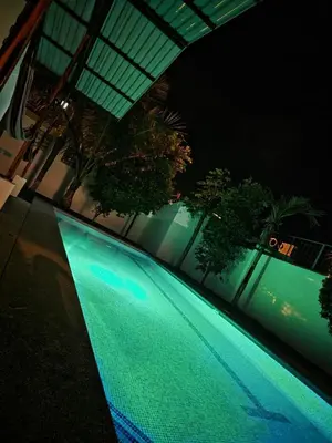 a swimming pool at night with green lights at Casa Alegria in Jacó