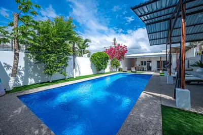 a swimming pool in the backyard of a house at Casa Alegria in Jacó