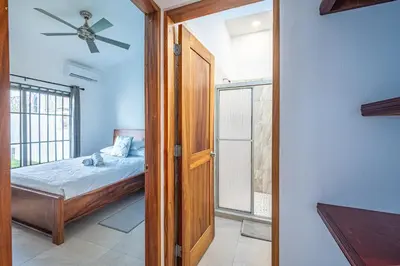 a bedroom with a bed and a ceiling fan at Casa Alegria in Jacó