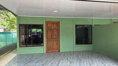 an empty room with green walls and a wooden door at Paquera apartment in Paquera
