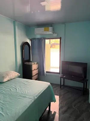 a bedroom with a bed and a dresser and a window at Paquera apartment in Paquera