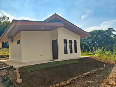 a small white house with a driveway at Casa Lapa in Aguas Zarcas