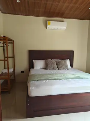 a bedroom with a bed with a wooden headboard at Casa Lapa in Aguas Zarcas