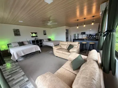 a large living room with a couch and a kitchen at Arenal cautiva in El Castillo de La Fortuna