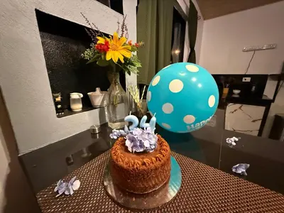 a table with a birthday cake and a balloon at Arenal cautiva in El Castillo de La Fortuna