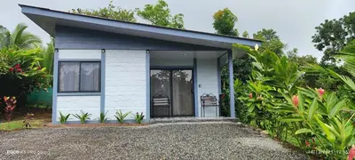 a small white cottage with a door in a garden at Casa de las aves in Guayabal