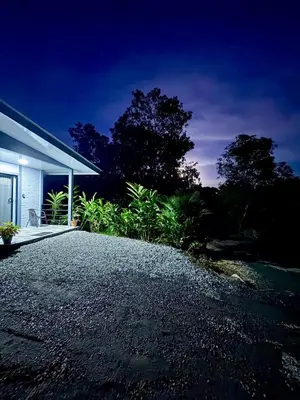 a gravel driveway next to a house at night at Casa de las aves in Guayabal