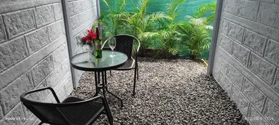 a table and two chairs and a vase with red flowers at Casa de las aves in Guayabal