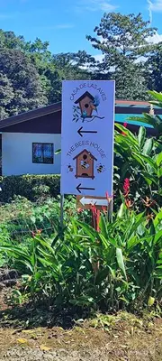 a sign in the grass in front of a house at Casa de las aves in Guayabal