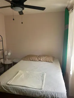 a bedroom with a bed with a ceiling fan at Surf House Aparment in Coco