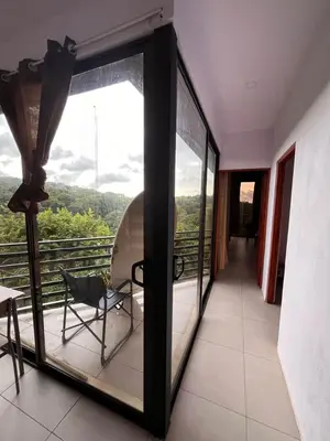 a room with a glass door with a chair on a balcony at Golden Sunset Loft in Tamarindo