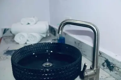 a bathroom sink with a blue glass bowl in a faucet at Golden Sunset Loft in Tamarindo