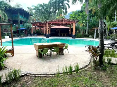 a table and chairs in front of a swimming pool at Walk-out Beachfront Condo - Surfer's Paradise in Playa Hermosa