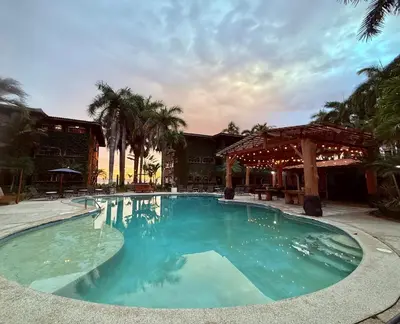 a large swimming pool in front of a resort at Walk-out Beachfront Condo - Surfer's Paradise in Playa Hermosa
