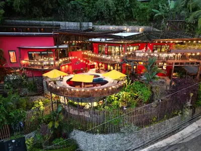 an outdoor restaurant with yellow umbrellas in front of a building at Villa Jardin in Quepos