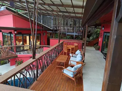 a balcony with chairs and tables on a building at Villa Jardin in Quepos