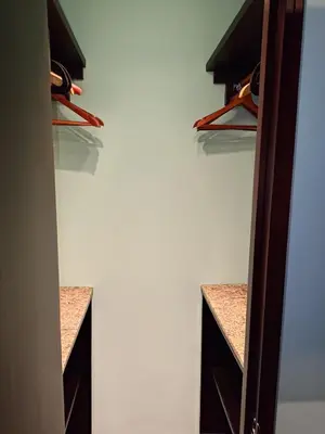 a walk in closet with brown cabinets and shelves at Villa Jardin in Quepos