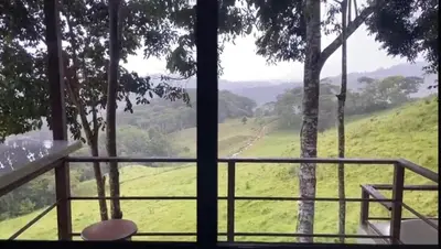 a balcony with a view of a green field at Casita El Perezoso in San Rafael