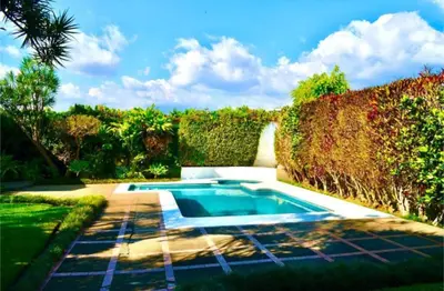 a swimming pool in the middle of a garden at Habitación Sabana in San José