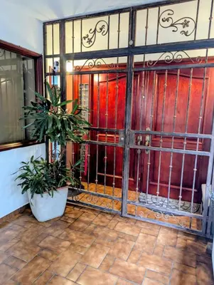 an entrance to a house with a gate and a potted plant at Habitación Sabana in San José