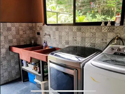 a kitchen with a sink and a washing machine at Paseo de Damitas in Quepos