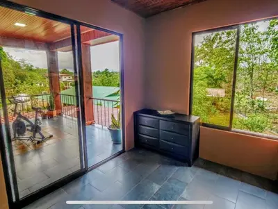 a room with a view of a balcony with sliding glass doors at Paseo de Damitas in Quepos