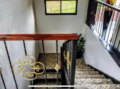 a staircase with a wooden railing and a window at Paseo de Damitas in Quepos