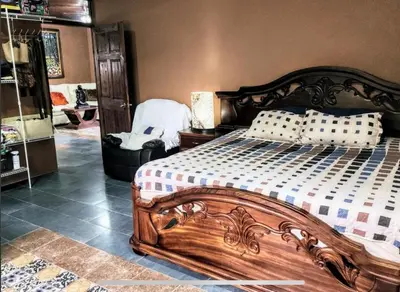 a bedroom with a wooden bed with pillows on it at Paseo de Damitas in Quepos