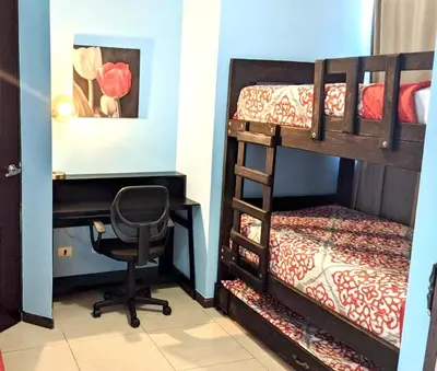 a desk and a chair in a room with bunk beds at CL127 Modern Penthouse in Jacó