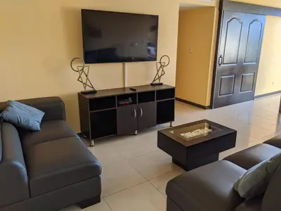 a living room with a couch and a flat screen tv at CL127 Modern Penthouse in Jacó