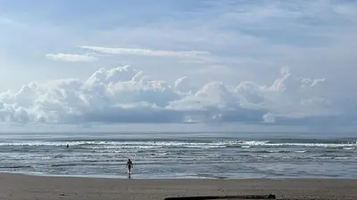 a person standing on a beach near the ocean at CL127 Modern Penthouse in Jacó