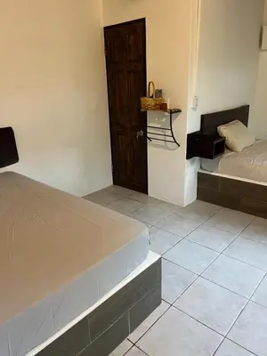 a bedroom with a bed and a door and a tiled floor at Green Point Nature Retreat in Nosara