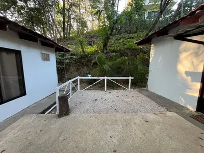 a porch of a white building with a wooden railing at Green Point Nature Retreat in Nosara