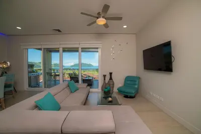 a living room with a couch and a flat screen tv at Miramar 2D -3 bedr 3 bath Ocean View in Herradura