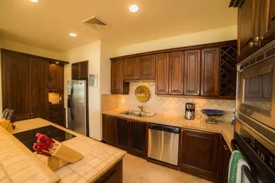a kitchen with wooden cabinets and a stainless steel refrigerator at Marbella 2A 3 BR in La Mona