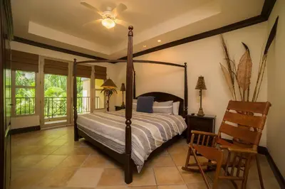a bedroom with a canopy bed and a chair at Marbella 2A 3 BR in La Mona