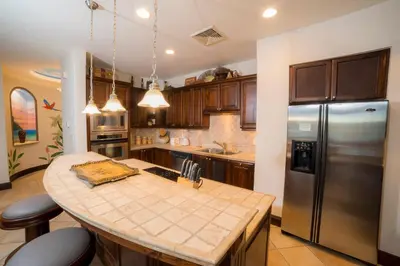 a kitchen with a stainless steel refrigerator and a counter at Marbella 3D 3 BR Ocean View in La Mona