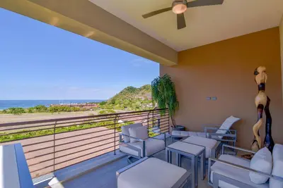 a room with chairs and a balcony with the ocean at Miramar 5B Family 3 bedr 3 bath in La Mona