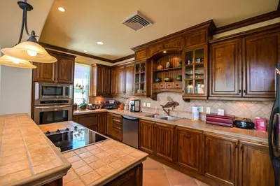 a large kitchen with wooden cabinets and a sink at Montebello 2C - 3 bdr 3 bath Ocean View in La Mona