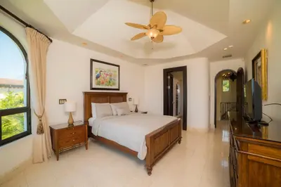 a bedroom with a bed and a flat screen tv at Casa Puesta del Sol 5 bdr - Ocean View Family in La Mona
