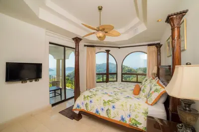 a bedroom with a bed and a large window at Casa Puesta del Sol 5 bdr - Ocean View Family in La Mona