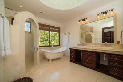 a bathroom with a tub and a large mirror at Casa Puesta del Sol 5 bdr - Ocean View Family in La Mona
