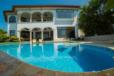 a large swimming pool in front of a house at Casa Puesta del Sol 5 bdr - Ocean View Family in La Mona