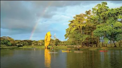 a group of people on kayaks on a lake with a rainbow at Beach Apartment with Pool and Lake - Playa Hermosa in Muñeco