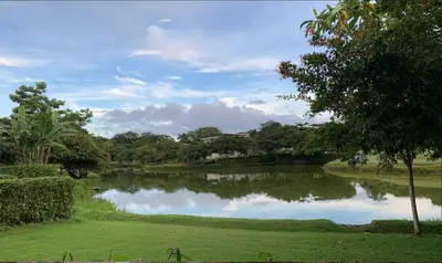 a large pond in a park with trees and grass at Beach Apartment with Pool and Lake - Playa Hermosa in Muñeco
